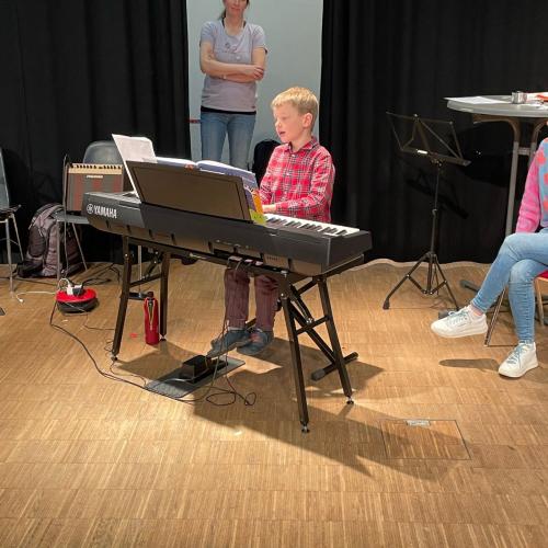 Kind mit Klavier beim Singen