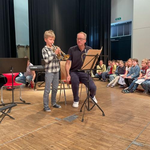 Kind mit Trompete und Musikschullehrer